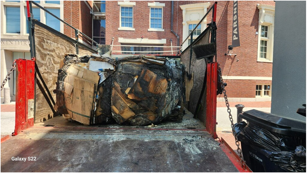 Charred cardboard boxes in a truck bed.